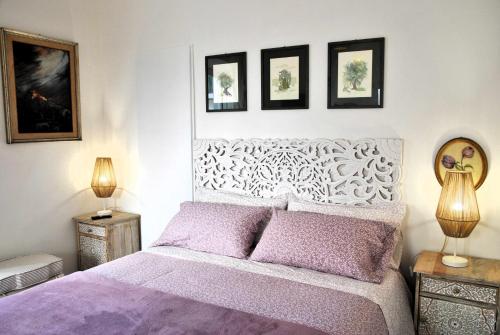 a bedroom with a purple bed with three pictures on the wall at Bed and Breakfast Casa Gioconda in Gaeta