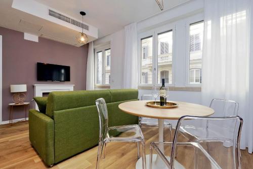 un soggiorno con divano verde e tavolo di La Flavia Design City Suites Rome a Roma