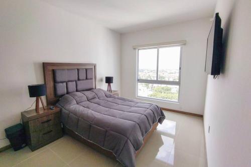 a bedroom with a large bed and a window at Escenia Comfort, 9th floor apt with awesome views! in Guadalajara