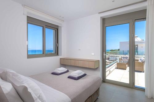 a white bedroom with a bed and a balcony at Villa Panaxia Kohille in Theologos