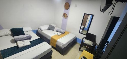 a small room with two beds and a mirror at Aparta Hotel la 80 Estadio in Medellín