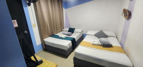a small room with two beds and a mirror at Aparta Hotel la 80 Estadio in Medellín