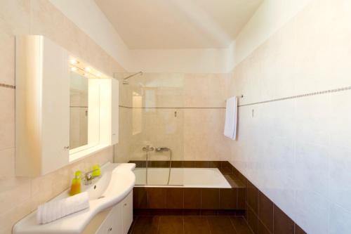 雷西姆農鎮的住宿－Villa Avra，带浴缸、水槽和淋浴的浴室