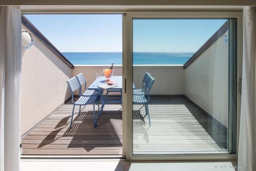 a balcony with a table and chairs and the ocean at Hotel San Pietro Palace in Finale Ligure