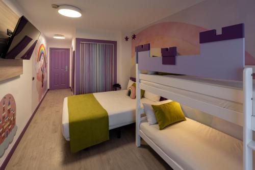 a bedroom with a bunk bed and a couch at Hotel Magic Fantasy in Oropesa del Mar