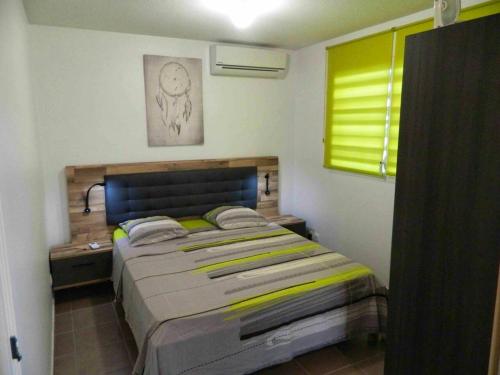 1 dormitorio con 1 cama grande en una habitación en Appartement d'une chambre a Le Moule a 30 m de la plage avec wifi, en Le Moule