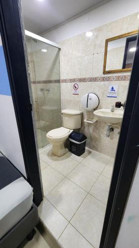 a bathroom with a toilet and a shower and a sink at Aparta Hotel la 80 Estadio in Medellín