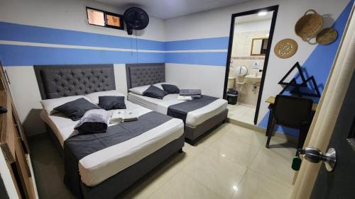 a hotel room with two beds and a mirror at Aparta Hotel la 80 Estadio in Medellín