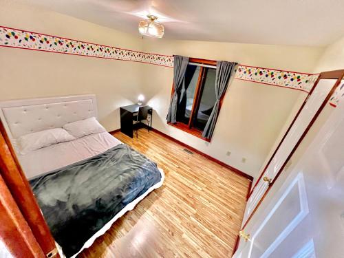 um pequeno quarto com uma cama e uma janela em Private room with dedicated Bath in Newmarket - Free Parking em Newmarket