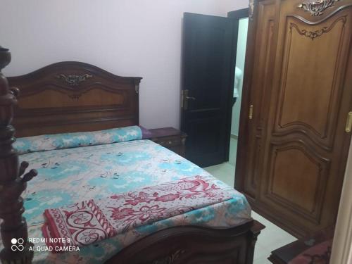 een slaapkamer met een bed en een houten bedframe bij المندرة بحرى in Alexandrië