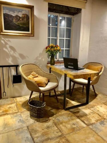 a table with a laptop on it with two chairs at Hotel Valle Místico in Tepoztlán