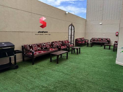 ターイフにあるمنتجع سمو الوسام Wesam Highness Resortの緑の芝生のある部屋のソファ