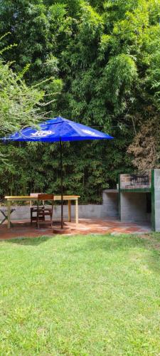 a blue umbrella over a picnic table and a bench at Cabaña Las Casuarinas del Delta de Tigre in Dique Luján
