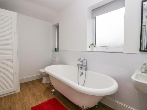 ein weißes Badezimmer mit einer Badewanne und einem Waschbecken in der Unterkunft 7 New Street in Sedbergh