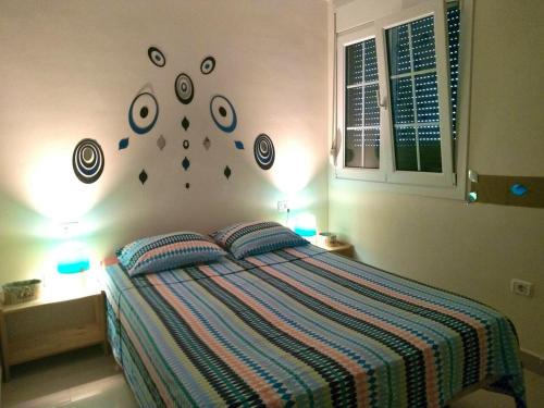 1 dormitorio con 1 cama con 2 almohadas y relojes en la pared en 2 bedrooms property with terrace and wifi at San Cristobal de La Laguna, en Punta del Hidalgo