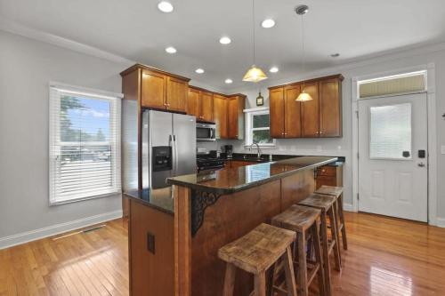 a kitchen with a large island with stools in it at Housepitality - The Victorian Vacation Home in Columbus