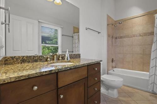 a bathroom with a sink and a toilet and a tub at Housepitality - The Victorian Vacation Home in Columbus