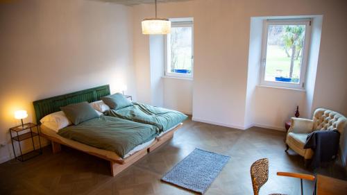 a bedroom with a bed and a chair and a window at Casa Gatti BnB Gastronomia e Benessere in Motto