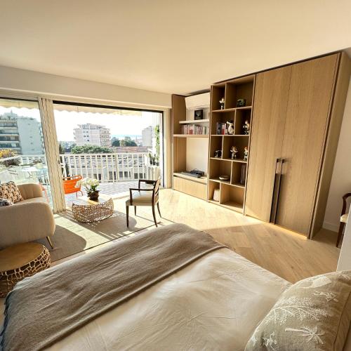 une chambre avec un grand lit et une grande fenêtre dans l'établissement Cannes vue mer, à Cannes