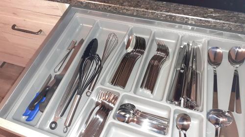 un récipient en plastique rempli d'ustensiles dans un tiroir dans l'établissement Rollstuhlgerechte 80m² grosse Ferienwohnung in Ostfriesland, à Utarp
