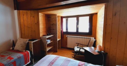 una camera con letto, scrivania e finestra di Il Maiolandro a Noasca