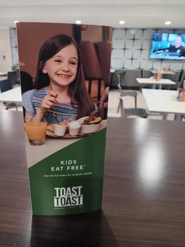 a sign for a restaurant with a little girl eating food at Holiday Inn Hotel & Suites Ann Arbor University of Michigan Area by IHG in Ann Arbor
