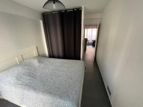 - une chambre avec un lit et un rideau noir dans l'établissement Appartement moderne face gare St Charles, à Marseille