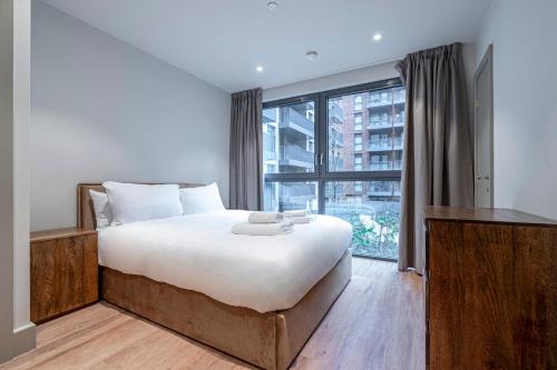 sypialnia z dużym łóżkiem i dużym oknem w obiekcie The Sessile w Londynie