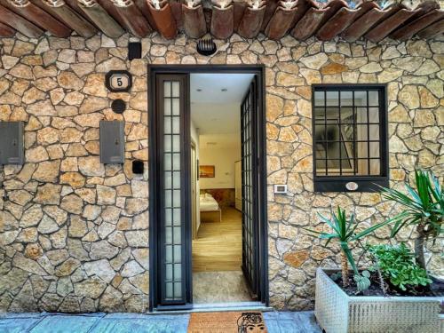 een stenen muur met een deuropening naar een huis bij MaMa5 in Palermo