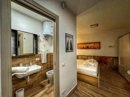 een badkamer met een wastafel, een toilet en een bed bij MaMa5 in Palermo