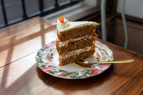 a slice of cake on a plate with a fork at Hotel Boutique La Posada in Sucre
