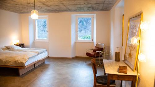 a bedroom with a bed and a desk and a chair at Casa Gatti BnB Gastronomia e Benessere in Motto