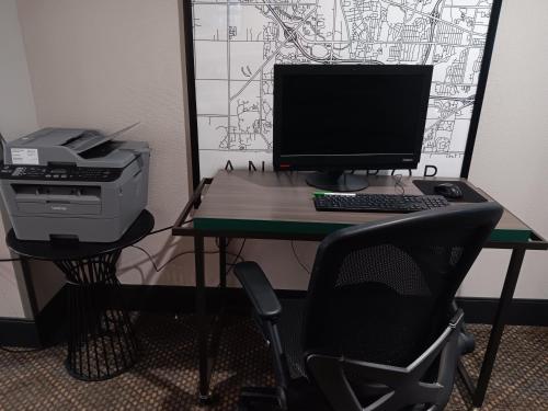 a desk with a computer monitor and a printer at Holiday Inn Hotel & Suites Ann Arbor University of Michigan Area by IHG in Ann Arbor