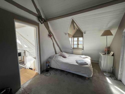 ein Schlafzimmer mit einem Bett und einem großen Fenster in der Unterkunft Maison avec cheminée ancienne in Dives-sur-Mer
