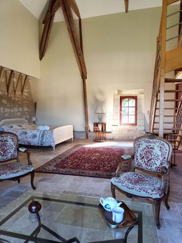 a living room with two beds and chairs and a table at Chambres d'hôtes au Château de Gizeux in Gizeux