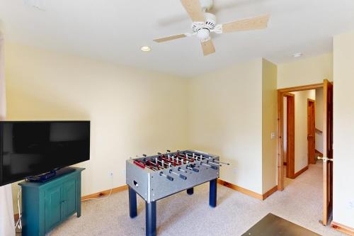 a room with a ping pong table and a flat screen tv at Slopeslide Lakehouse in McHenry