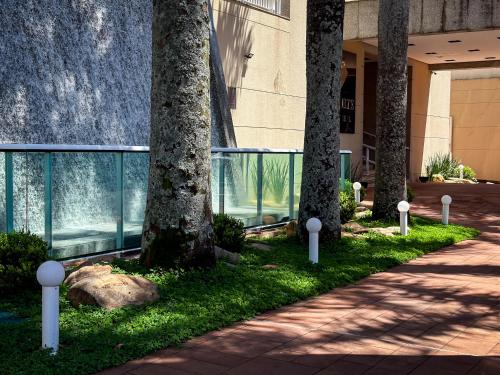 una pasarela frente a un edificio con árboles en Hotel Cianorte Diamond, en Cianorte