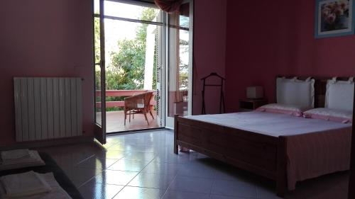 a bedroom with a large bed and a sliding glass door at Giardini Irlandesi B&B in Ruffano
