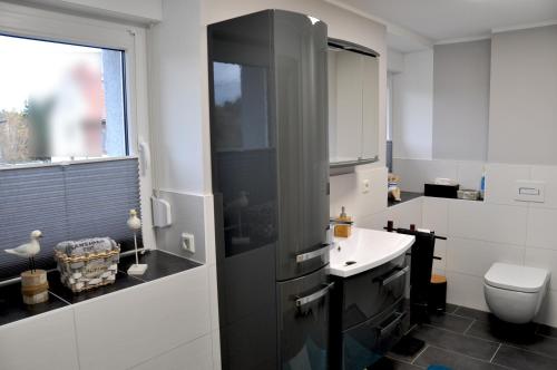 a white bathroom with a sink and a toilet at Ferienhaus Am Mühlenberg Thale Westerhausen in Thale