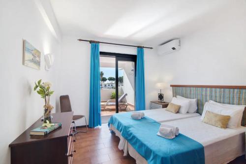 ein Schlafzimmer mit einem großen Bett mit einer blauen Decke in der Unterkunft Apartamento Ivone by Sunnyway in Albufeira