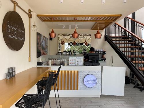 a coffee shop with a counter and chairs in a building at Margarett Hotel in Valladolid