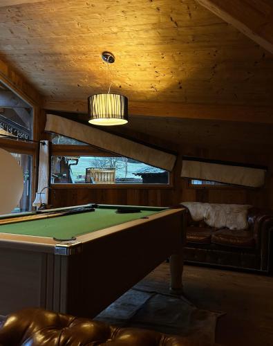 a living room with a pool table and a ceiling at le A by neige et roc in Morzine