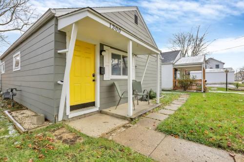 a small gray house with a yellow door at Housepitality - The Southern Orchards Cottage in Columbus
