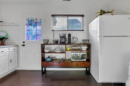 a kitchen with a counter with a microwave and a refrigerator at Housepitality - The Southern Orchards Cottage in Columbus