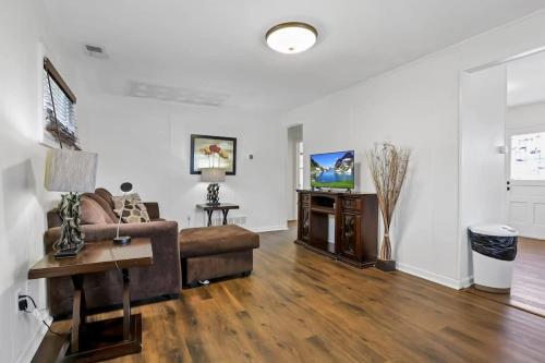 a living room with a couch and a tv at Housepitality - The Southern Orchards Cottage in Columbus