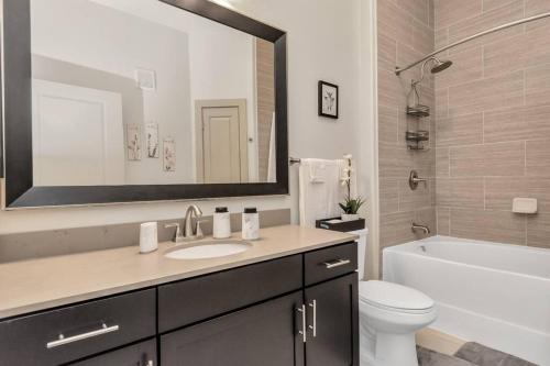 uma casa de banho com um lavatório, um WC e um espelho. em Lively Modern 1-Bedroom in Med Center em Houston