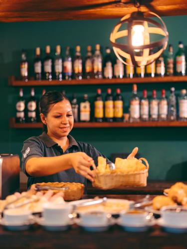 a woman behind a counter with a basket of food at Reserva Natural Iguazú - Posada Puerto Bemberg in Puerto Libertad