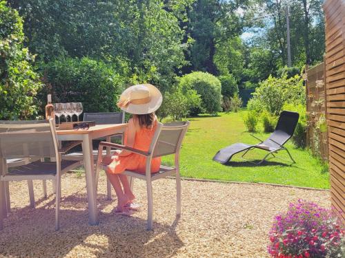 a woman sitting at a table in a garden at Studio 4 pers avec balcon et jardin in Sprimont