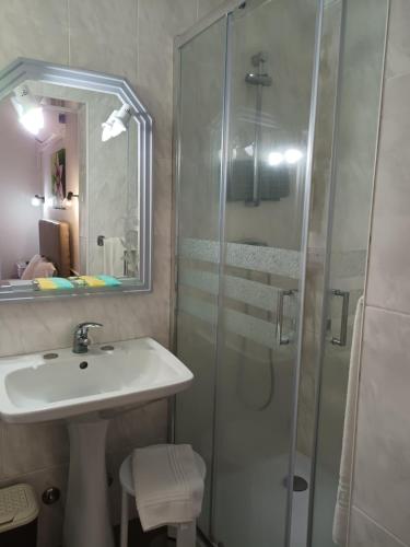 a bathroom with a sink and a glass shower at Hotel Branco I in Praia da Vitória