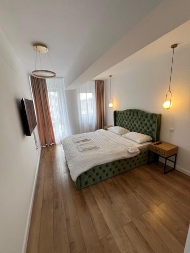 a bedroom with a bed and a green couch at EightApartament in Bistriţa